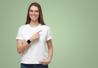 Pretty girl pointing right, looking excited, isolated on green copy space background