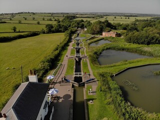 Poster - Drone view of a green field with canal locks and houses