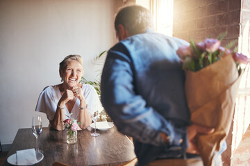 Elderly, couple and flowers on a date for surprise, love and romance in their house. Senior woman, man and retirement together with bouquet to celebrate marriage, birthday or anniversary in the home