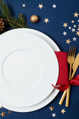 Wall Mural - Festive christmas table setting with golden cutlery and porcelain plate and christmas decoration. Mockup for place card, dinner invitation, restaurant menu template. Copy space