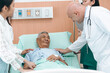 © chokniti - professional doctor standing by explain the treatment information via male elderly patient lying in bed in private hospital sickroom. The treatment program is suitable for people to socialize elderly
