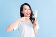 © Timeimage - Young Asian woman eating ice cream on background