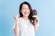 © Timeimage - Young Asian woman eating ice cream on background