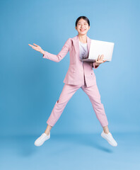 Canvas Print - Full length image of young Asian business woman on background