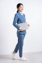 Full Length Image Of Young Asian Businesswoman Holding Laptop