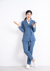 Canvas Print - Full length image of young Asian business woman using smartphone