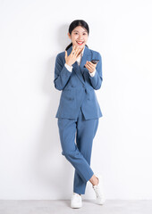 Wall Mural - Full length image of young Asian business woman using smartphone