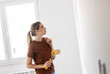 © BalanceFormCreative - Young female using paint roller to decorate walls in her new home.