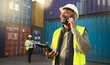 © N Felix/peopleimages.com - Logistics, shipping and construction worker on the phone with tablet in shipyard. Transportation engineer on smartphone in delivery, freight and international distribution business in container yard