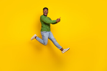 Wall Mural - Full length body size view of handsome trendy guy using device jumping fooling isolated on vivid yellow color background