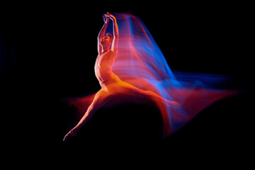 Wall Mural - Aspiration. Solo performance of flexible male ballet dancer dancing isolated on dark background in glowing colorful neon light. Grace, art, beauty