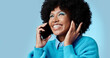 © N Felix/peopleimages.com - Black woman, talking on smartphone and smiling on blue background in studio mockup. Stylish african american lady with fashion afro, cellphone conversation and happy talk on 5g communication network