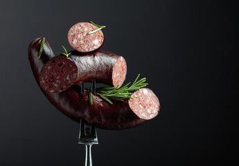 Wall Mural - Spanish black pudding or blood sausage with rosemary on a fork.