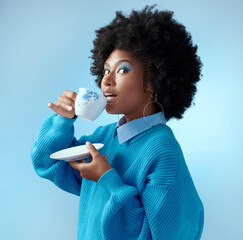 afro hair, tea cup and black woman with fashion, style and trend clothes on blue background in studi