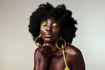 Wall Mural - Black woman, beauty and retro fashion, afro hair and blow air kiss with gold makeup and jewelry on studio background. Portrait, gesture and face of female cosmetics model from Jamaica flirting inside