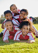 © N Lawrenson/peopleimages.com - Team, children and happy on field in sports after win in match, game or competition. Girl, smile and together after teamwork in soccer, football or sport on grass for motivation, diversity and unity
