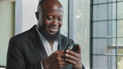 Male adult businessman investor man holding smartphone texting messages in social networks taking notes on phone using mobile business apps for e-commerce buying shares online modern tech in office