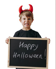 Cute Little Boy With Red Devil Horns And Black Board With Happy Halloween Text. Transparent Background Png