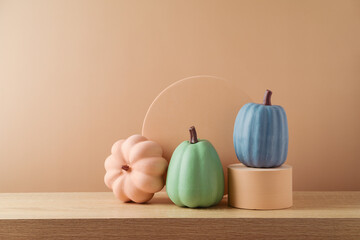 Wall Mural - Modern still life composition for Halloween or Thanksgiving  holiday. Colorful pumpkins on podium over beige background