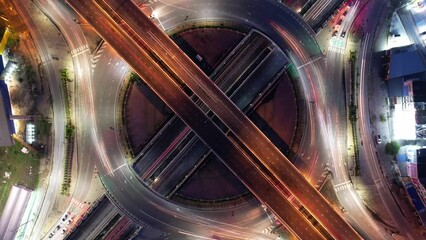 Wall Mural - Hyperlapse time-lapse of car traffic transportation above circle roundabout road in Asian city. Drone aerial view fly in circle, high angle. Public transport or commuter city life concept