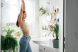 © Katecat - Young woman stretching in bathroom. Body positivity, confort home zone, wellness and lifestyle