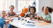 © JenkoAtaman - Happy multinational group of children making Halloween home decorations together