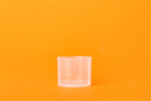 Empty measuring cup on orange background