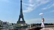 © Oleksandra - a beautiful young girl dances and spins near the Eiffel Tower with an openwork sun umbrella she is happy rejoices can be used for any advertising for any joy and happiness. High quality 4k footage