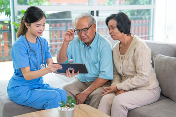 Wall Mural - Close up pretty Asian nurse or doctor sit on sofa and use tablet to give suggestion or consult data to couple senior man and woman at clinic or hospital.