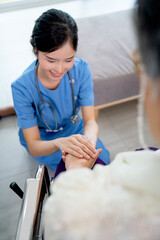 Wall Mural - Close up hands of nurse or doctor hold senior woman hands who sit on wheelchair with concept of take care and support elderly people in clinic or hospital center.