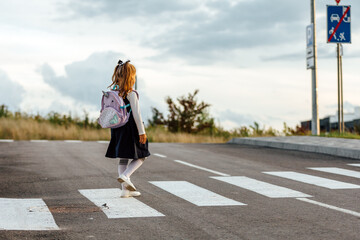  schoolgirl crosses the road at a pedestrian crossing
