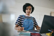 © Siphosethu F/peopleimages.com - Black woman writing notes, studying on laptop and working on living room desk from home. African American girl, digital learning from inside her house and working on elearning education course online