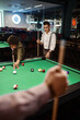 Friends playing billiards selective focus