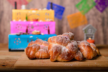 Pan De Muertos On Wooden Table With Altar In The Background. Typical Dessert Of The Day Of The Dead Celebration.