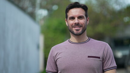 Portrait of a young handsome man in 30s walking toward camera smiling. Happy male person walks forward