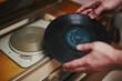 © Irina Burakova - Vinyl record, spinning on turntable, Vintage record player with radio 60's. Mens hands putting vintage record in vinyl player