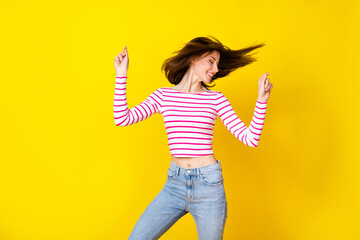 Canvas Print - Photo portrait of lovely young lady raise arms snap fingers dancing dressed trendy striped garment isolated on yellow color background