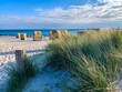 View of the sandy beach, traditional north german beach chairs and beach grass on the island Fehmarn on Baltic sea