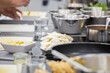 © ADDICTIVE STOCK - Kitchen table with stainless pots and cooked Asian dish at cooking workshop
