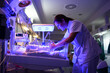 © ADDICTIVE STOCK - Nurse touching fragile newborn in neonatal incubator