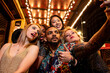 © ADDICTIVE STOCK - Happy multiracial friends taking selfie on smartphone during party