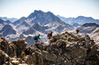 © ADDICTIVE STOCK - Traveling friends climbing rocky peak