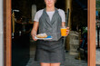 Waitress carrying pastry and orange juice to costumers