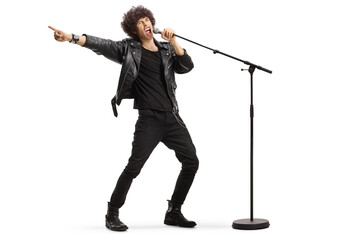 Wall Mural - Male singer in a leather jacket singing loud on a microphone