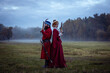 Duel of a man and a woman in 17th century costumes using antique pistols. Enemies stand back to back befor duel begin