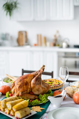 Wall Mural - thanksgiving dinner with traditional roasted turkey and grilled corn in blurred kitchen