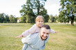 © Julija - Playful handsome bearded Caucasian father having piggyback with his adorable daughter.