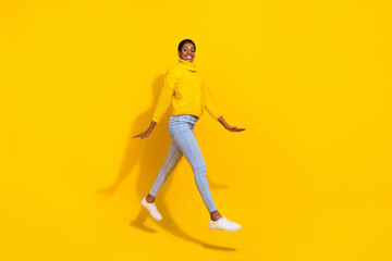 Wall Mural - Full length body size view of attractive cheerful trendy slender skinny girl jumping going isolated over bright yellow color background