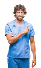 Wall Mural - Handsome hispanic surgeon doctor man over isolated background cheerful with a smile of face pointing with hand and finger up to the side with happy and natural expression on face