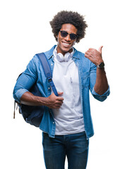 Wall Mural - afro american man wearing headphones and backpack over isolated background pointing and showing with